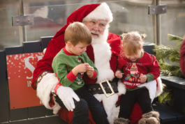 Two children sit on Santa's knees